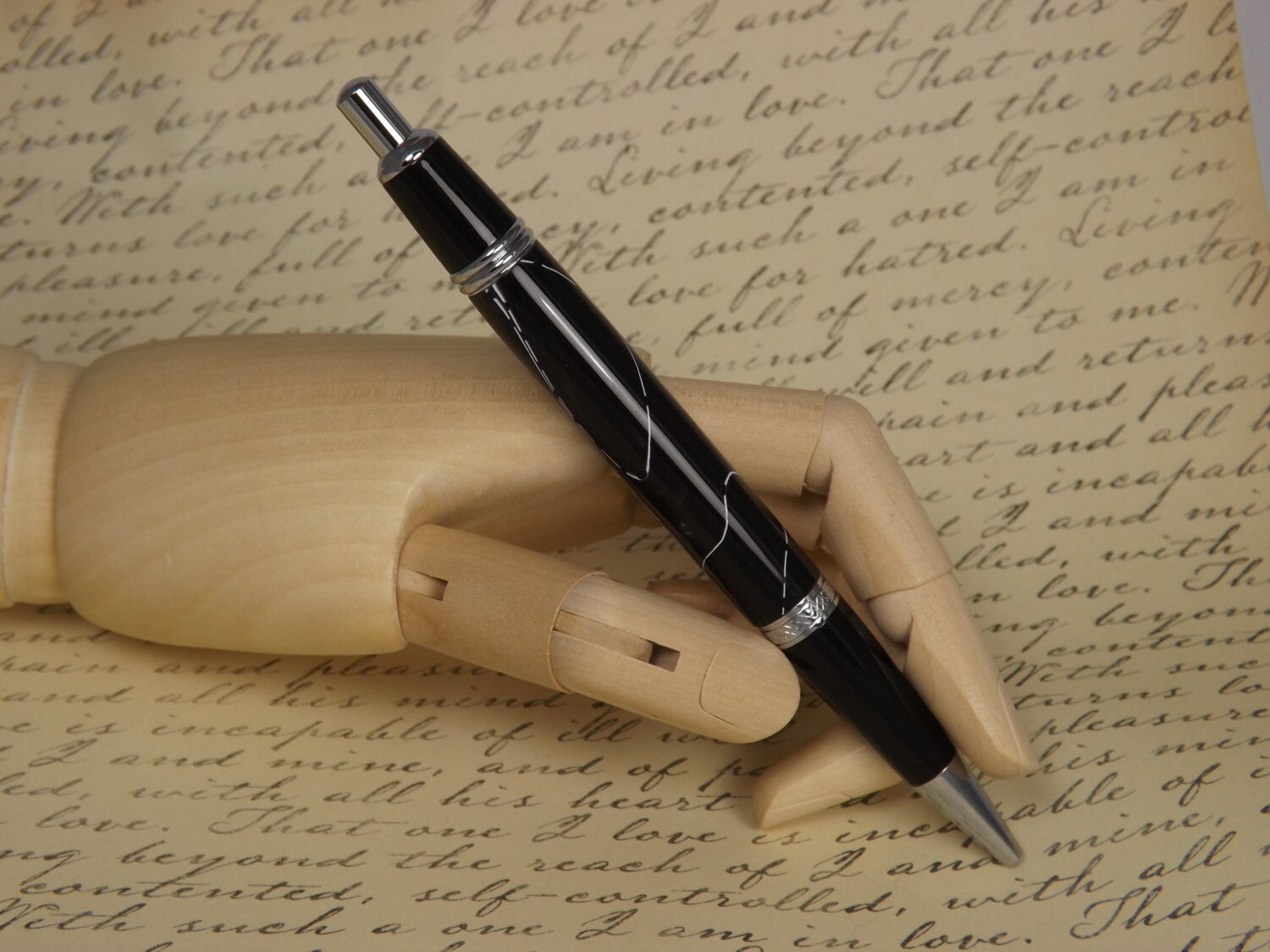 Handmade Chrome Sierra Button Click Pen with a black acrylic body showing white accents.