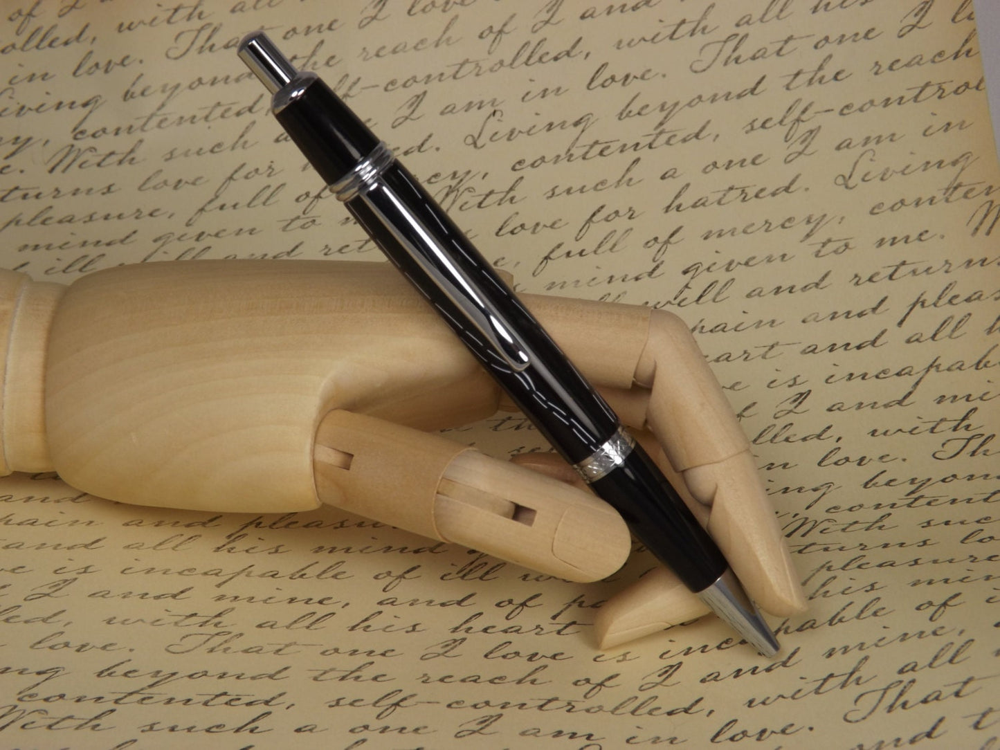 Handmade Chrome Sierra Button Click Pen with a black acrylic body showing white accents.