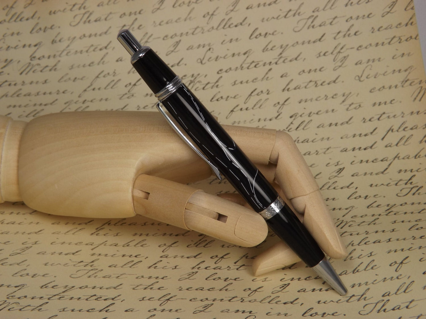 Handmade Chrome Sierra Button Click Pen with a black acrylic body showing white accents.