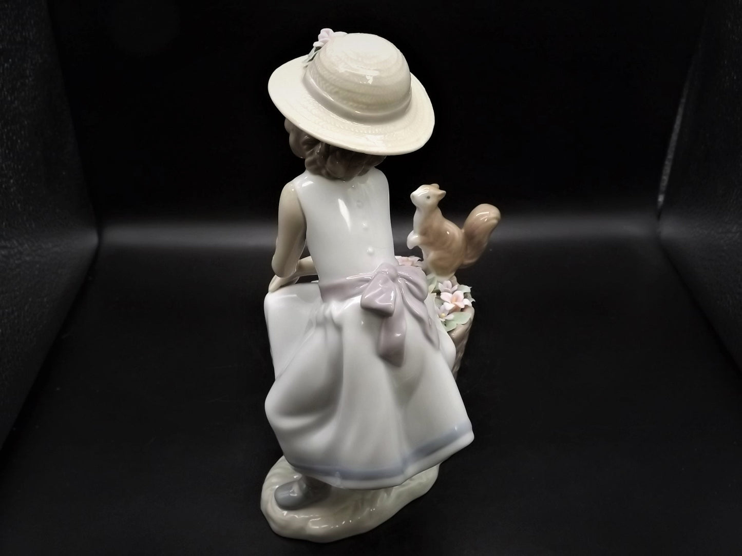 Vintage Lladro "Hello Little Squirrel" #6825 with original box. Girl and squirrel with flowers. 2 petals missing as shown in photos.