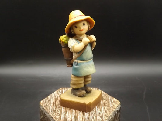 Vintage Anri "Harvest Time" Light carved wood figurine. Designed by Juan Ferrandiz. Young boy Carrying a basket of grapes. Number 4 club.