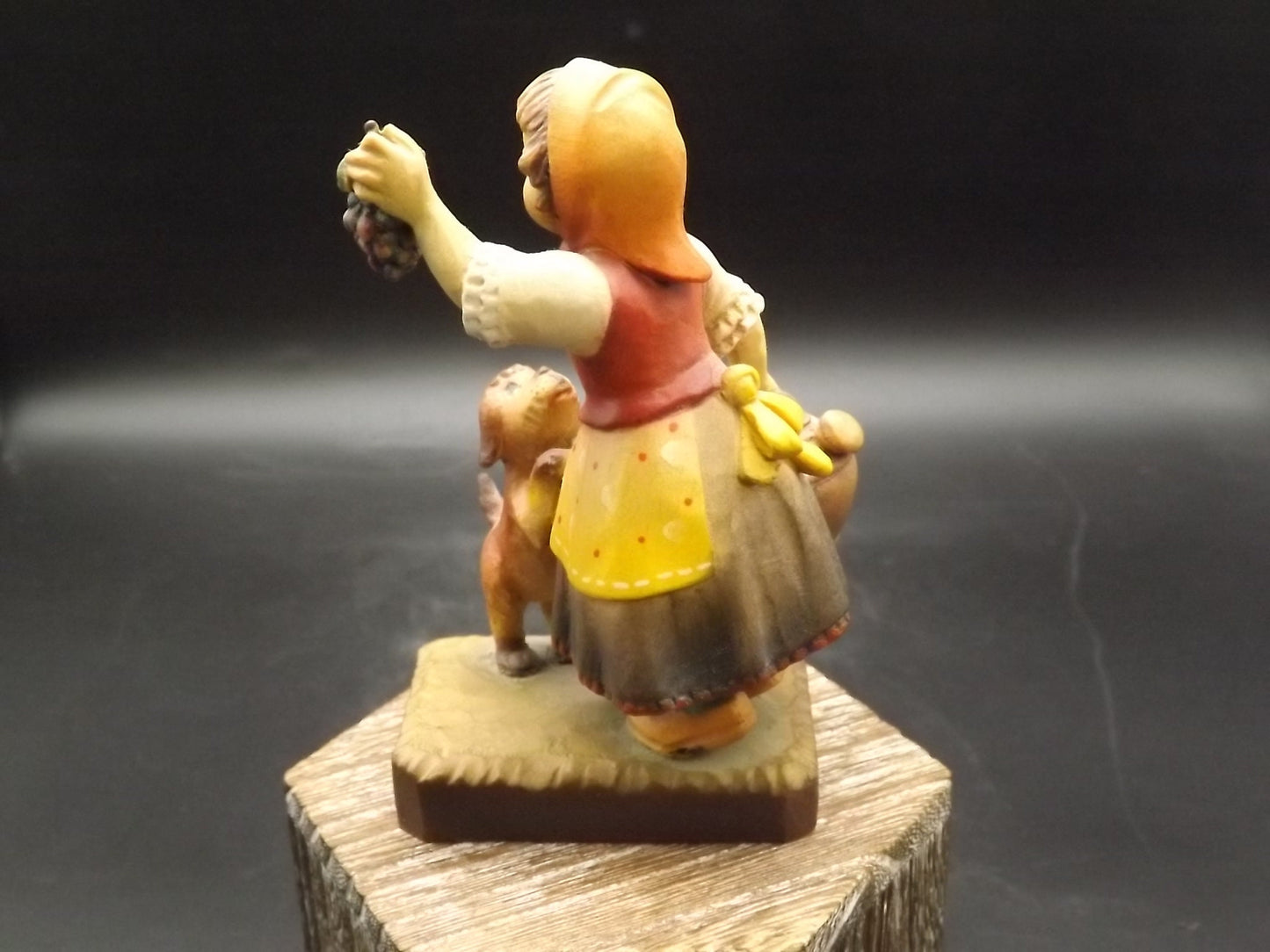 Vintage Anri "Harvest Help" carved wood figurine. Designed by Juan Ferrandiz. Young girl holding a bunch of grapes with her puppy.