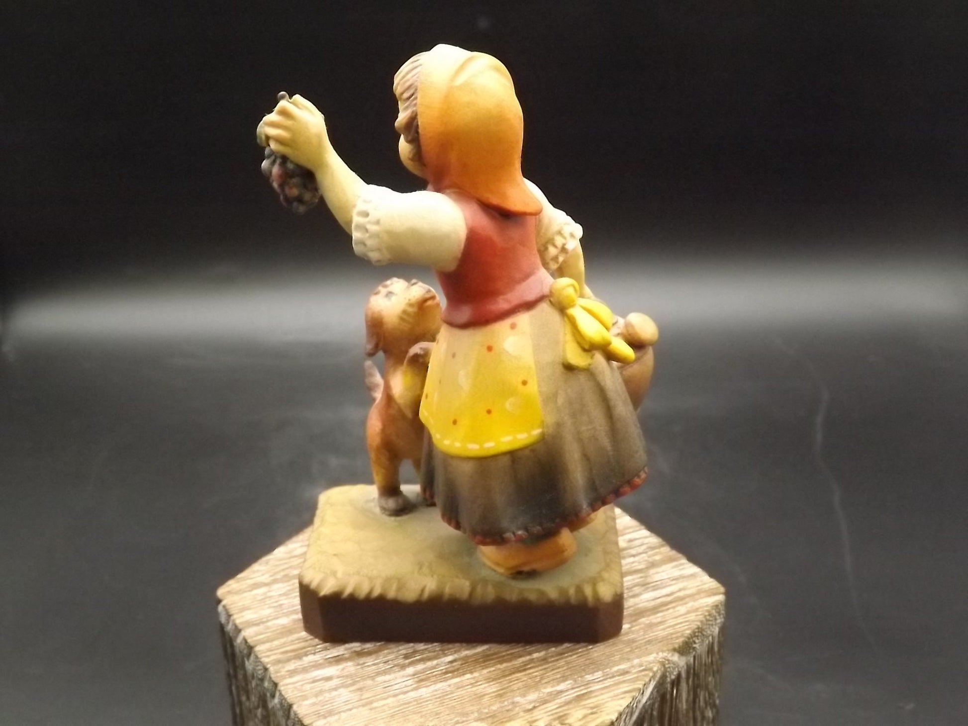 Vintage Anri "Harvest Help" carved wood figurine. Designed by Juan Ferrandiz. Young girl holding a bunch of grapes with her puppy.