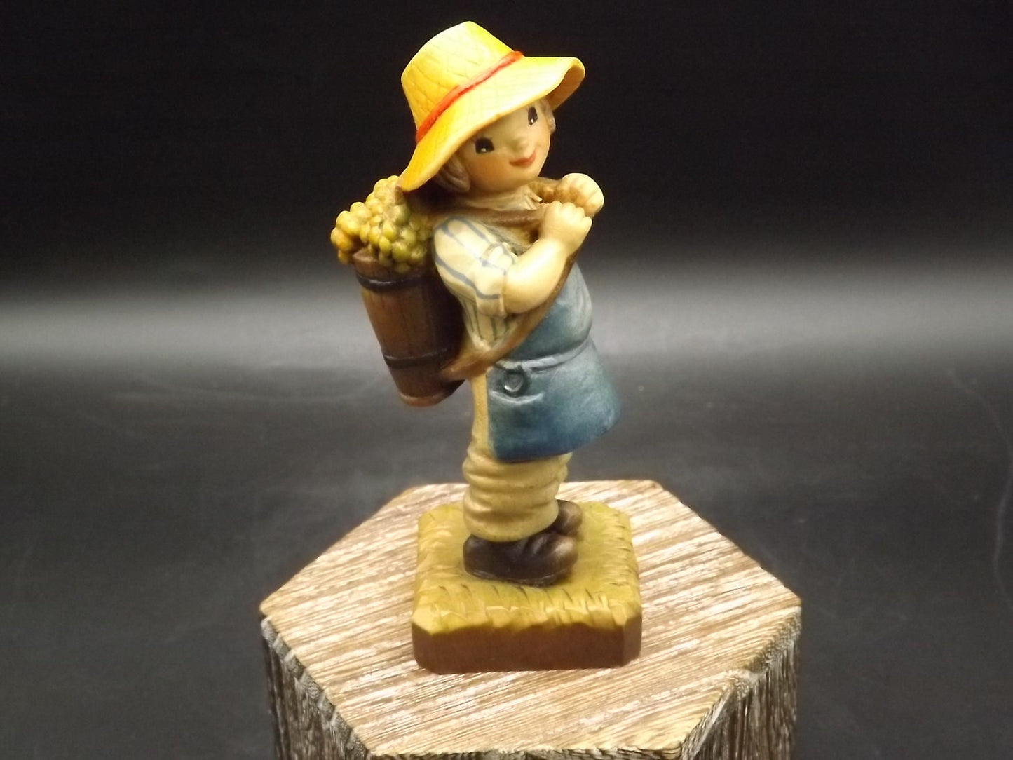 Vintage Anri "Harvest Time" Dark Blue carved wood figurine. Designed by Juan Ferrandiz. Young boy carrying a basket of grapes. Number 4 Club