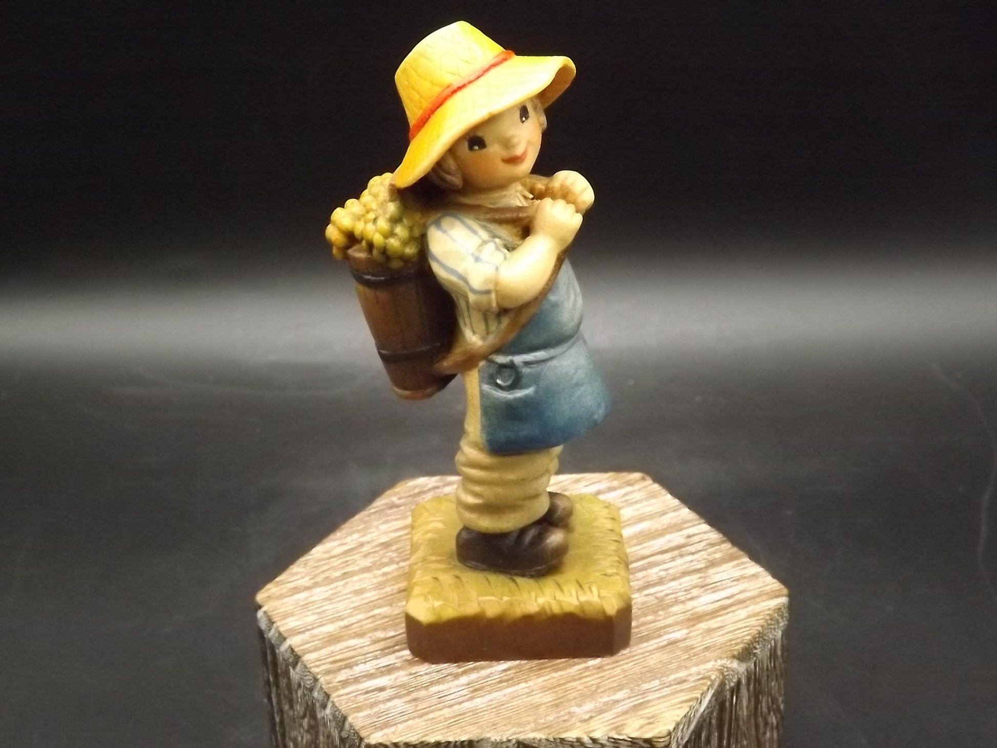 Vintage Anri "Harvest Time" Dark Blue carved wood figurine. Designed by Juan Ferrandiz. Young boy carrying a basket of grapes. Number 4 Club