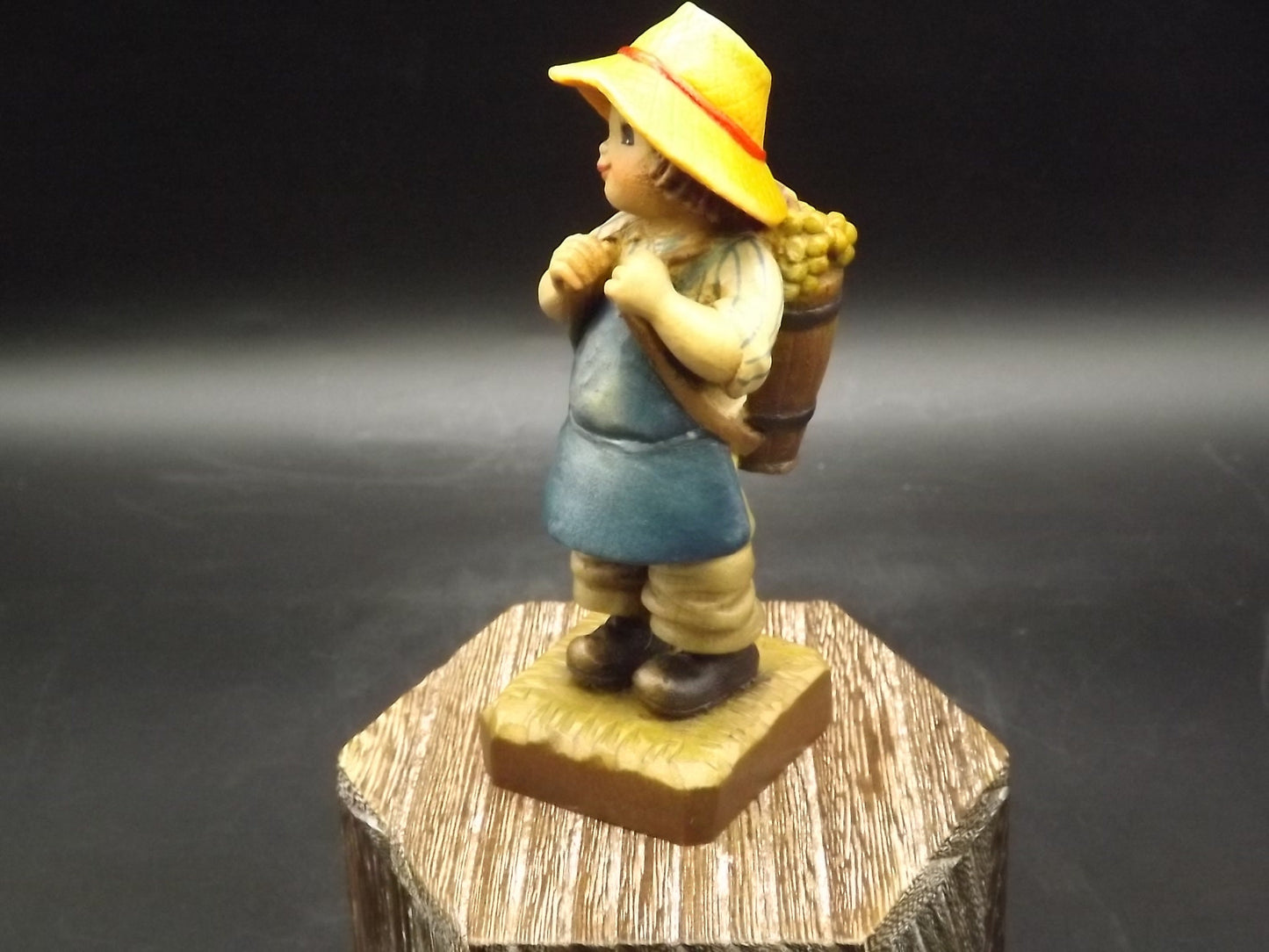 Vintage Anri "Harvest Time" Dark Blue carved wood figurine. Designed by Juan Ferrandiz. Young boy carrying a basket of grapes. Number 4 Club