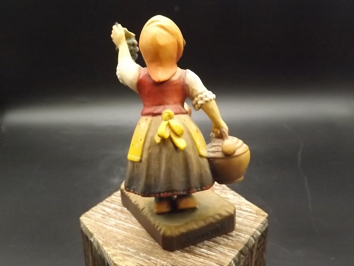 Vintage Anri "Harvest Help" carved wood figurine. Designed by Juan Ferrandiz. Young girl holding a bunch of grapes with her puppy.