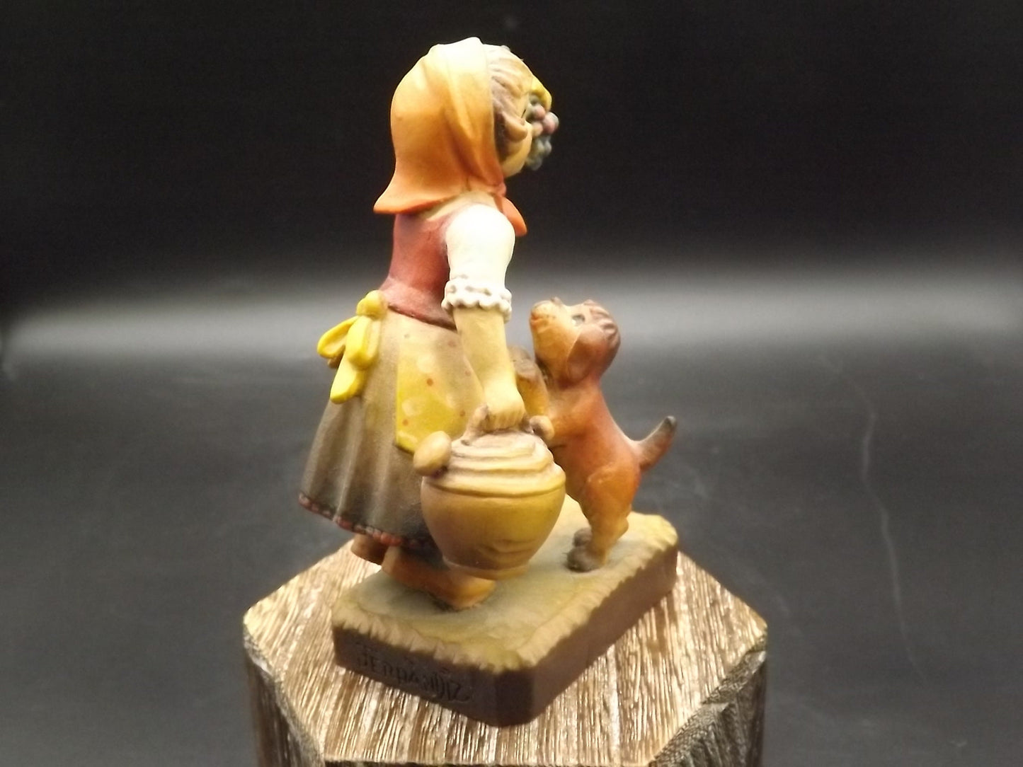 Vintage Anri "Harvest Help" carved wood figurine. Designed by Juan Ferrandiz. Young girl holding a bunch of grapes with her puppy.